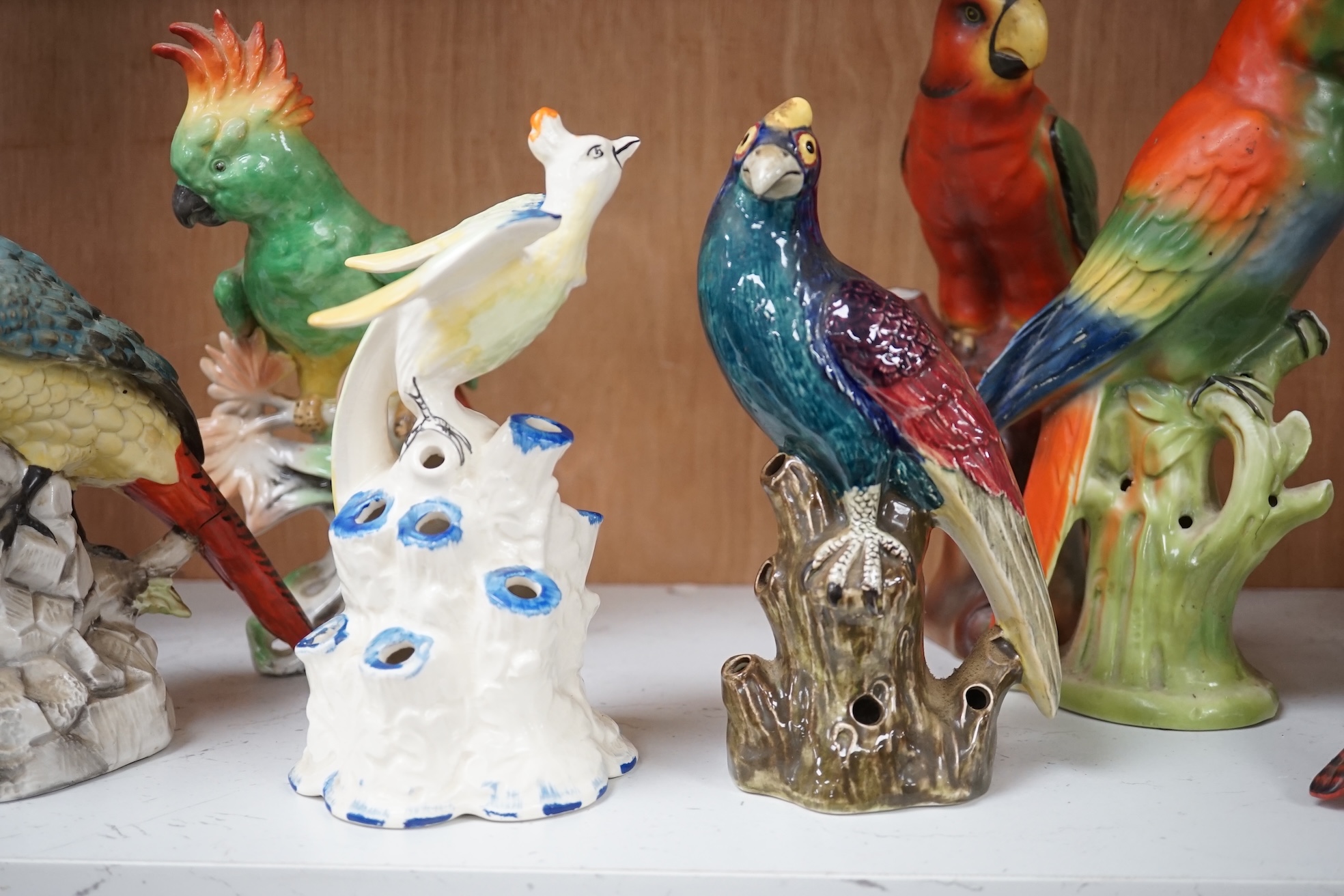 A group of twelve ceramic parrots including one by S Hancock & Sons, largest 24cm high. Condition - mostly good